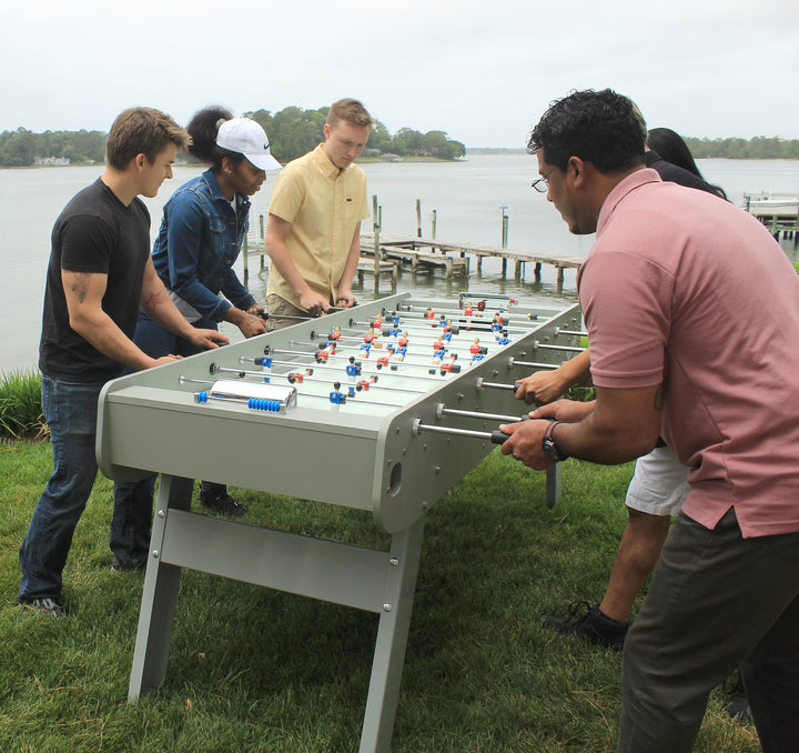 6 player lifestyle shot playing foosball in backyard