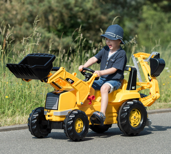 Lifestyle shot of child riding on made in germany pedal tractor caterpillar
