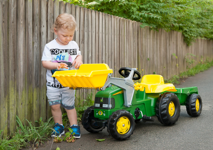 Lifestyle image of child loading front bucket of john deere made in germany resin vehicle