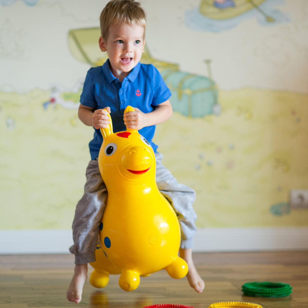 Little boy bouncing on a Rody horse hop toy.