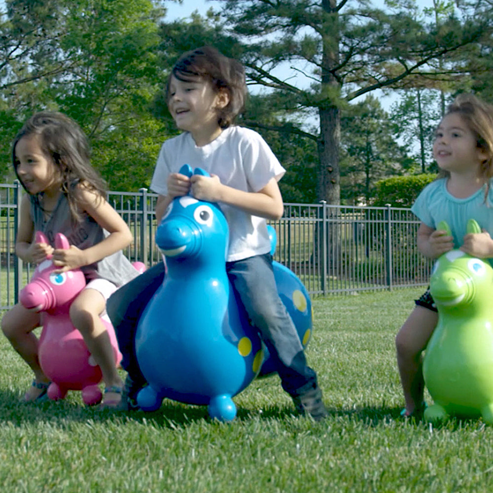 Three children bouncing on Kettler Hop toys outside.