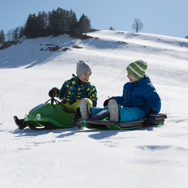 lifestyle image of two children on light weight snow sleds