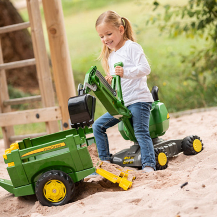 lifestyle image of john deere trailer being loaded by child with digger