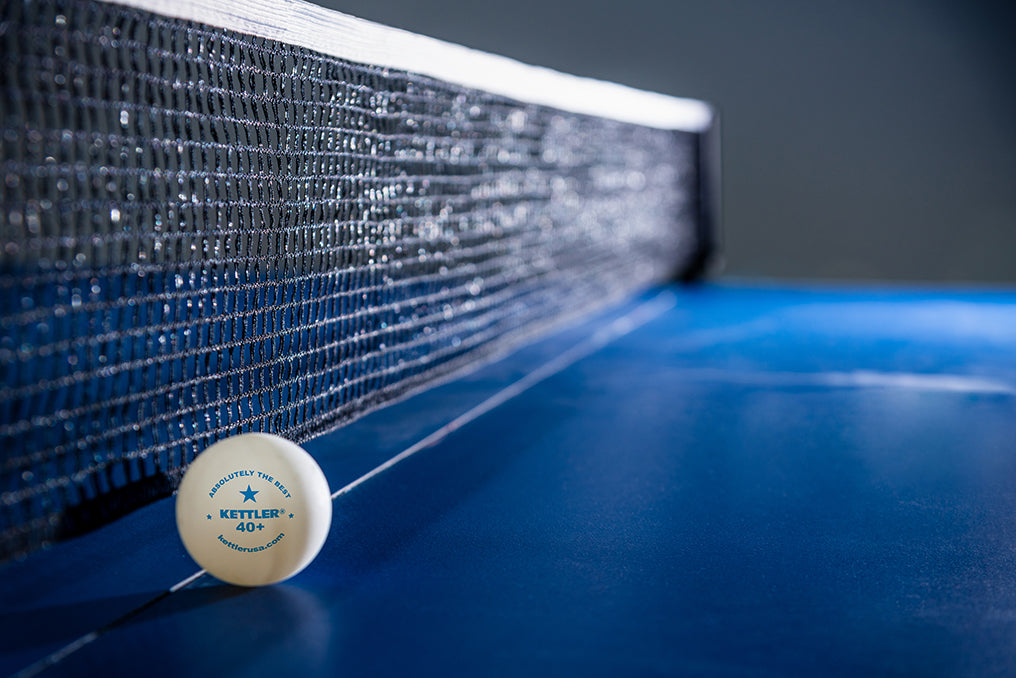 lifestyle shot of 1 star table tennis ball against net on table