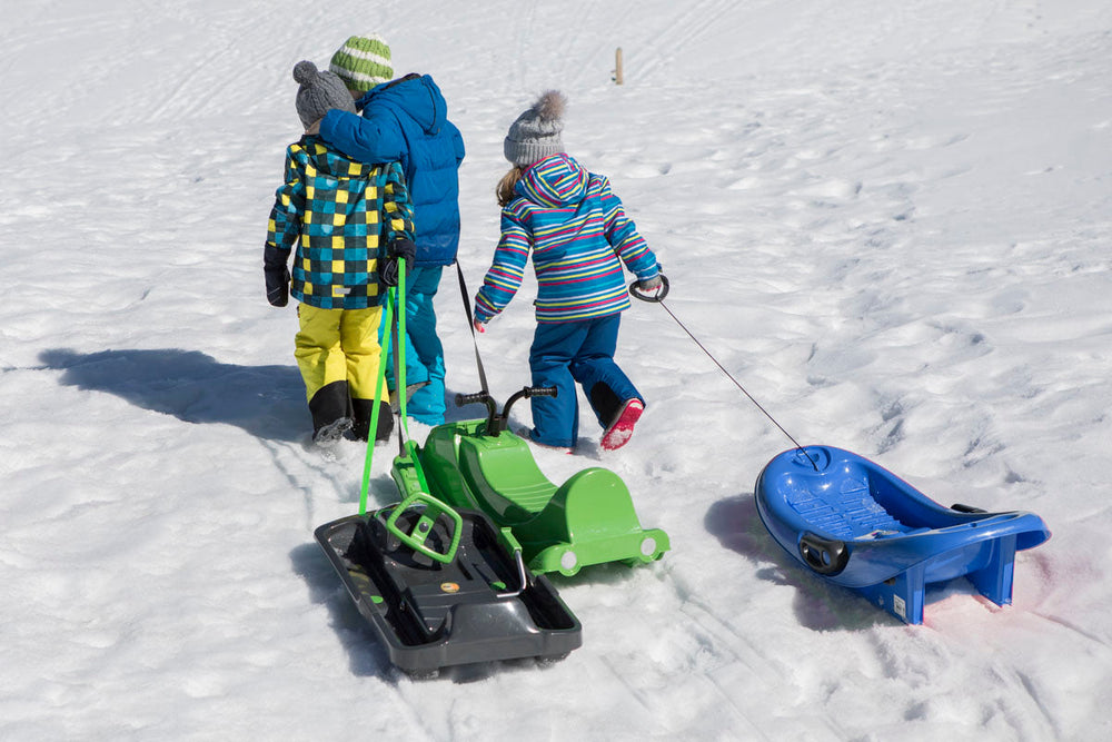 lifestyle image of children towing sleds by the tow strap 